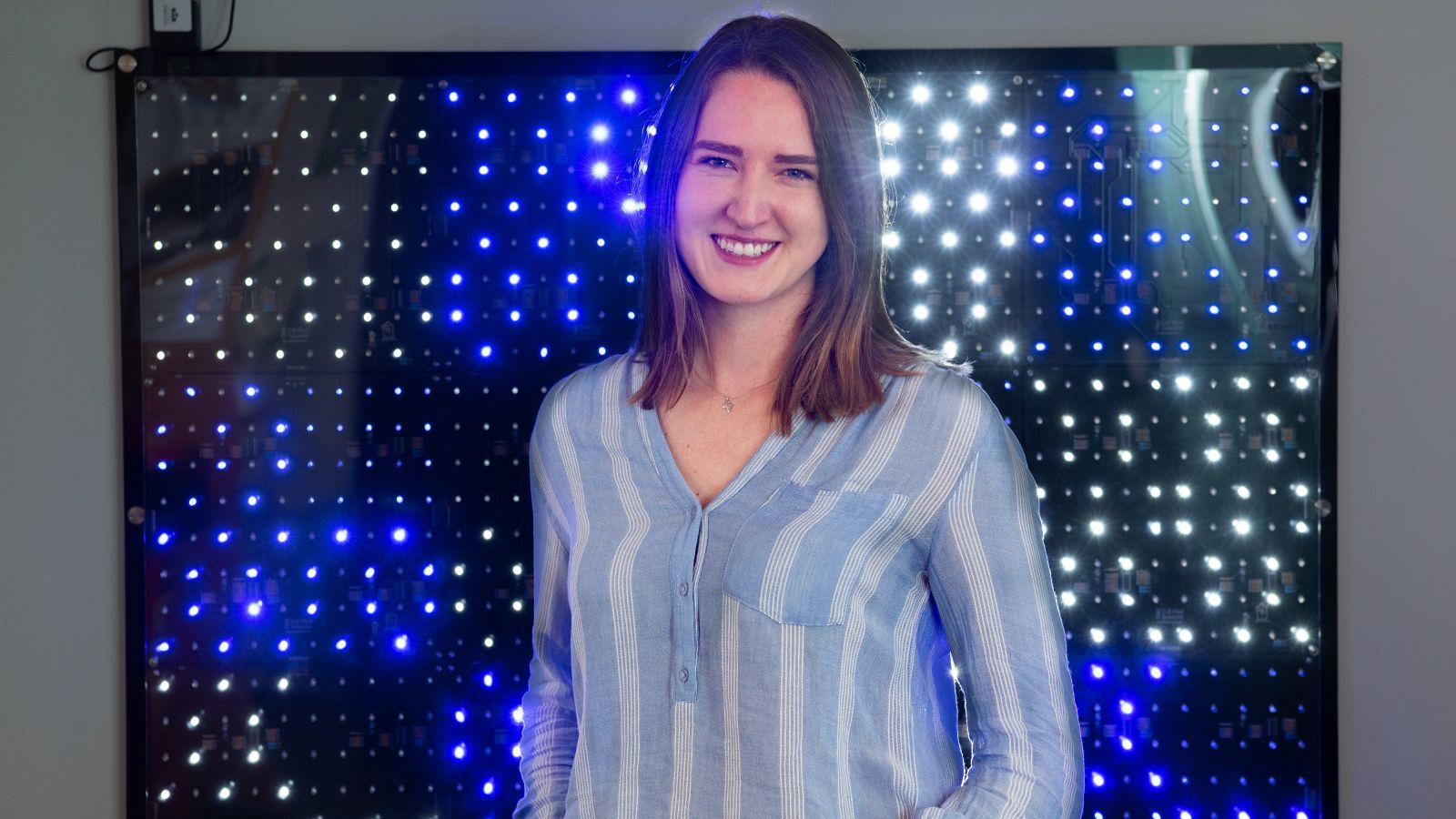 Christina Margetts  in front of a light sculpture.