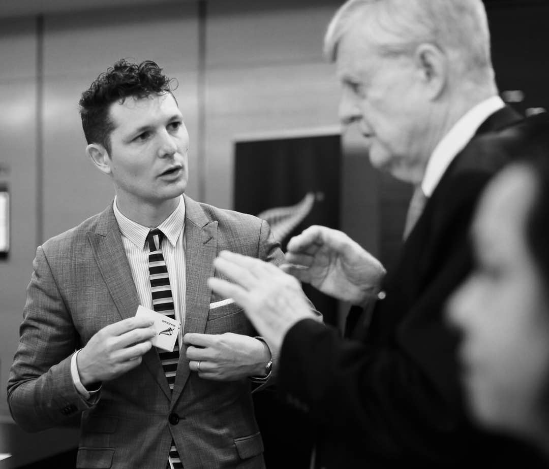 Adam McCnnochie speaking to a guest at a function.