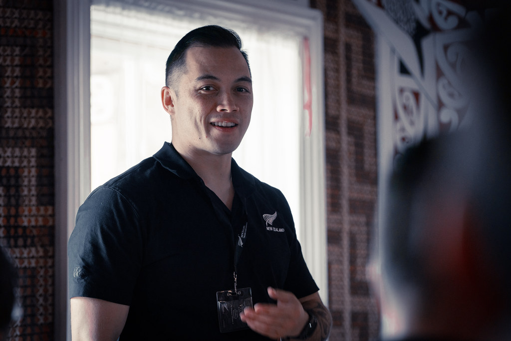 A man standing backlight in front of a window in a marae.