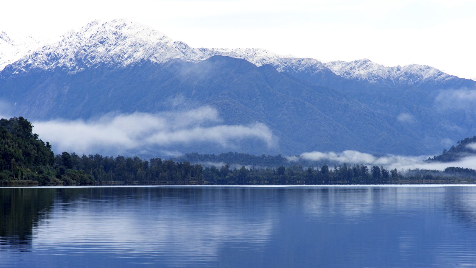 The shimmering water of Lake Mapourika with the Southern Alps in the background
