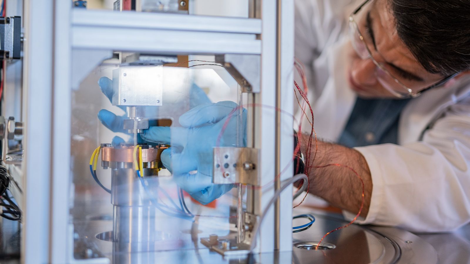 Scientist adjusting part of an experiment involving superconducting bearings..