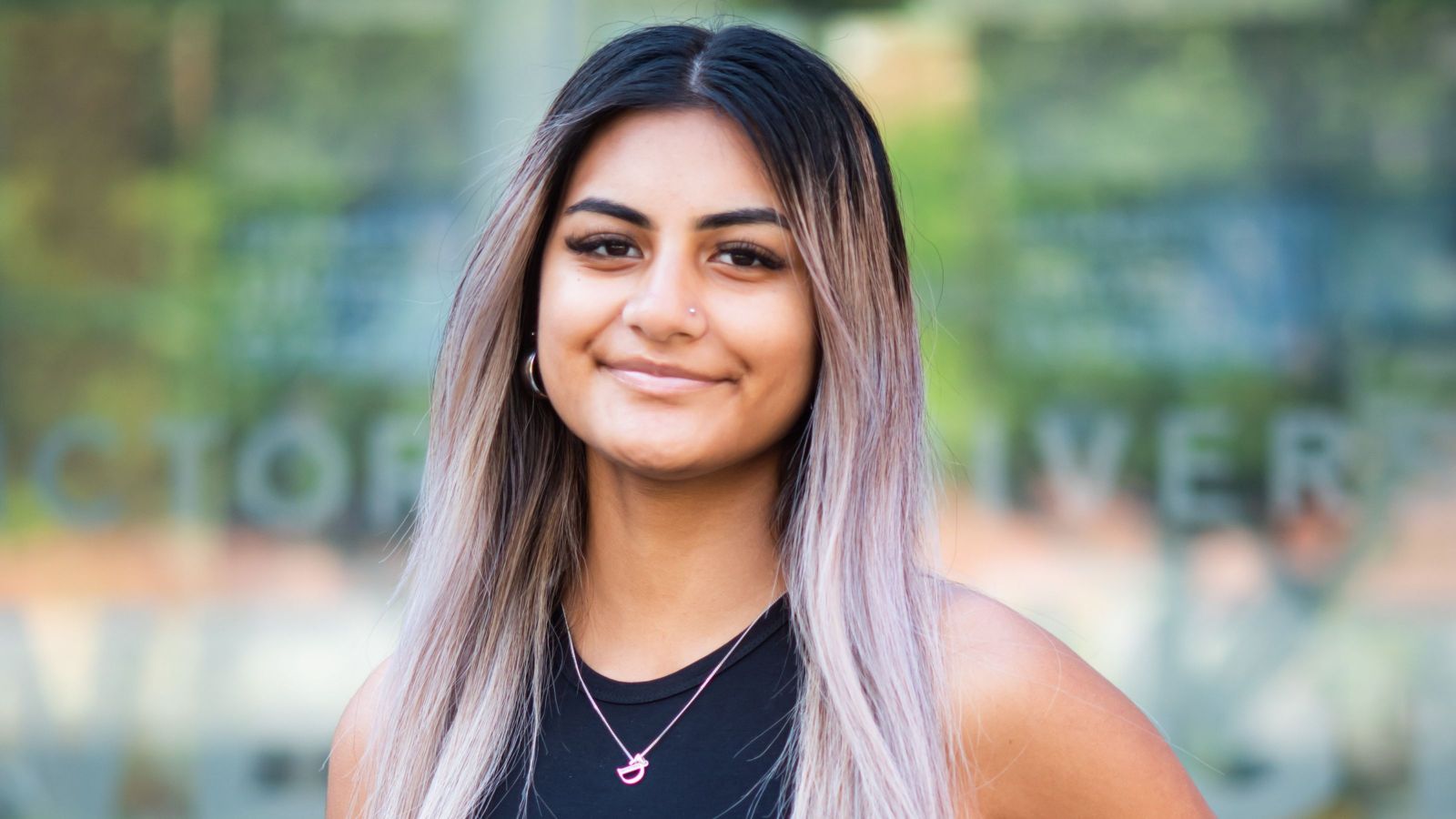 girl with very long purple-blond hair smiling with mouth closed