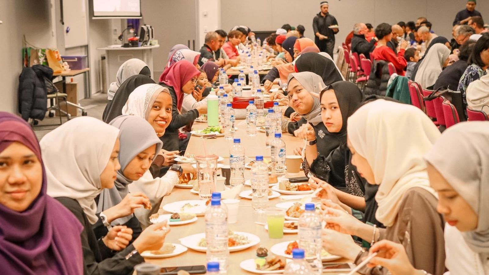 Students sharing meal at long table.