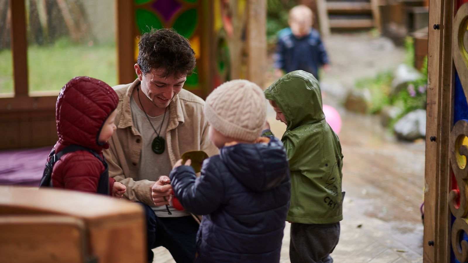 Early childhood education teacher and PhD student Josh interacting with three young children.