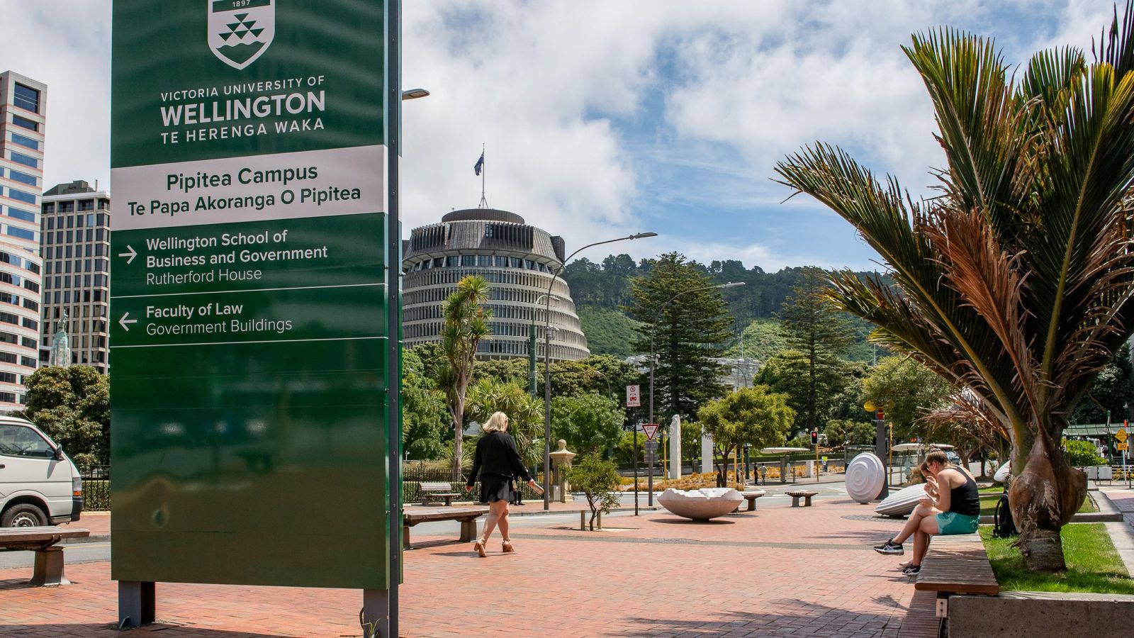View of signage for University campus with parliament building in the distance