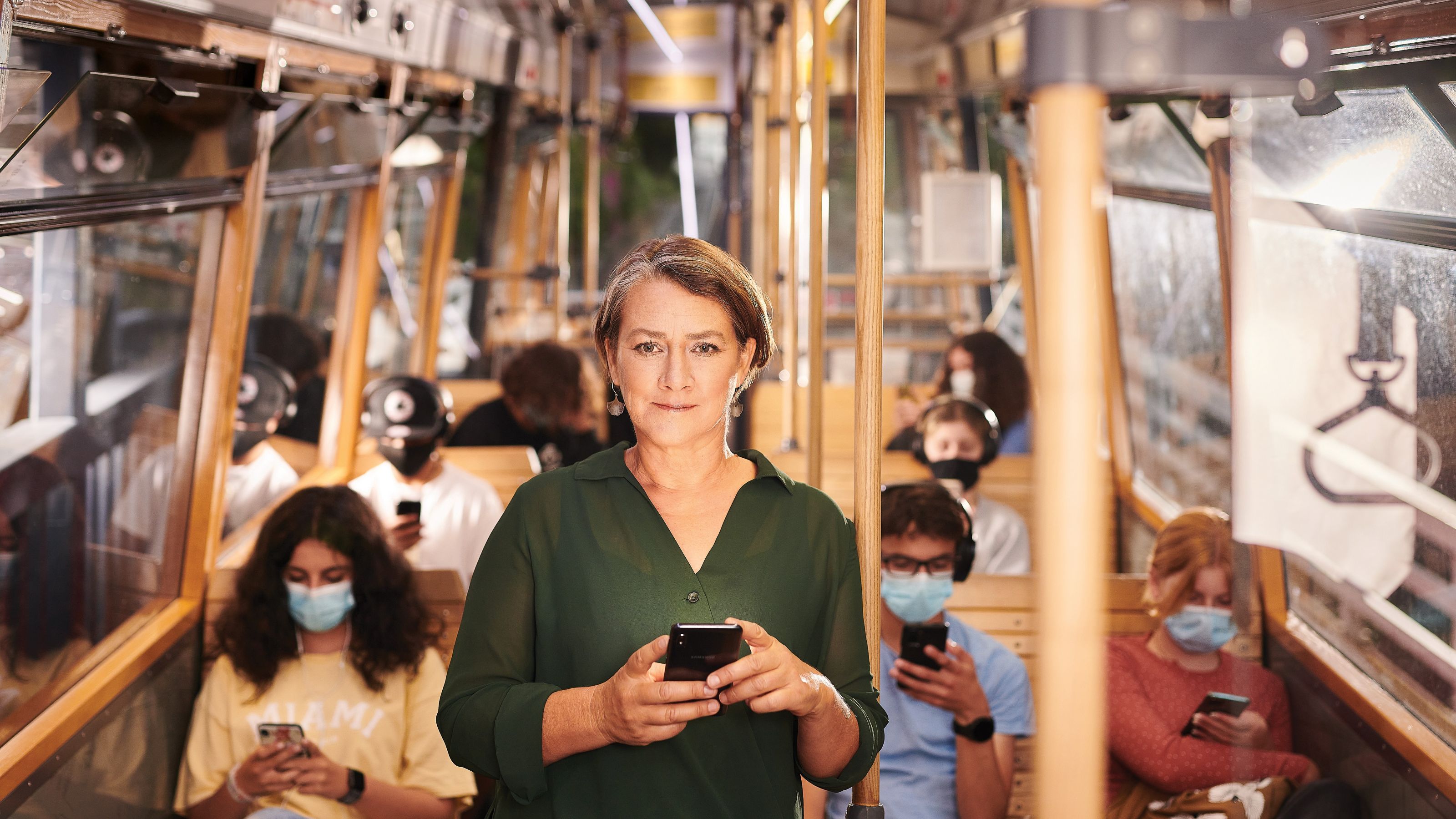 Associate Professor Terry Fleming standing inside the cable car holding cell phone.  