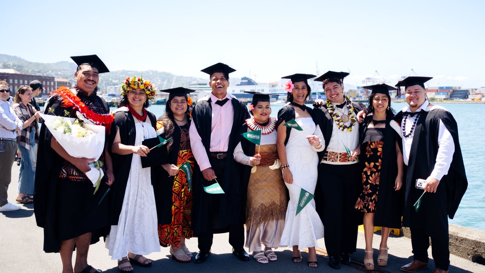 Large group of students waving flags after their graduation parade