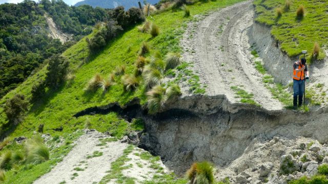 Will Ries (GNS Science) is using a GPS unit to measure the offset of a farm track that was damaged during the quake