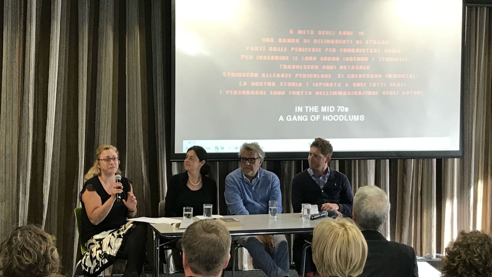 Dr Claudia Bernardi, Dr Barbara Pezzotti, author and judge Giancarlo De Cataldo, and Dr Alfio Leotta sit at a table and address the audience.