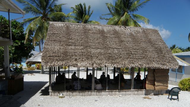 People sit in hut in Atafu Village 