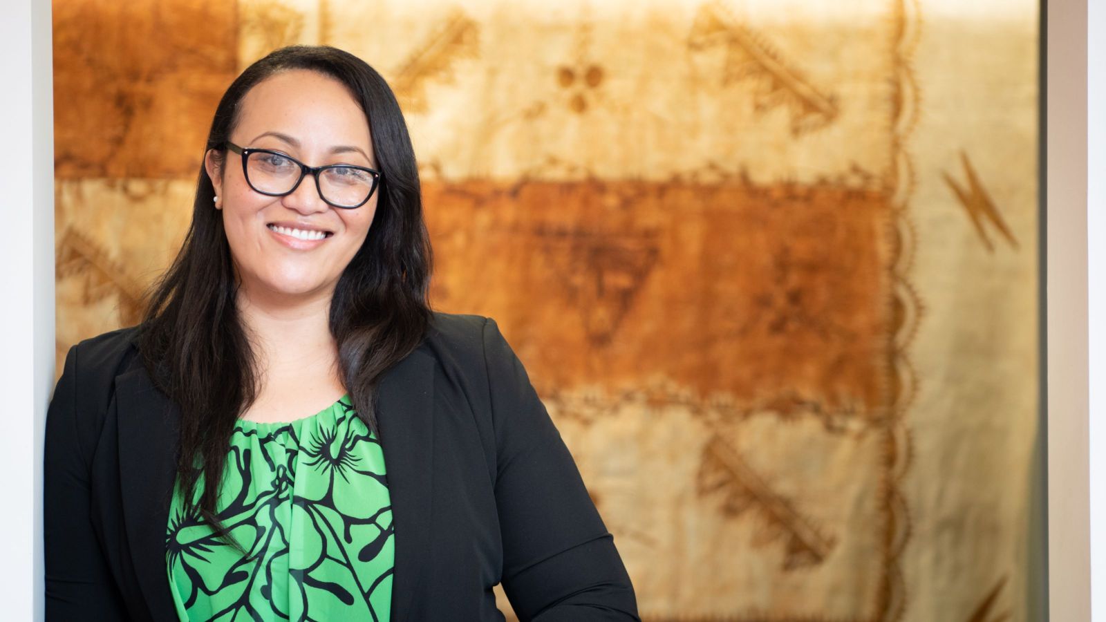 PhD Candidate Linda Fatialofa in front of a Samoan cloth.