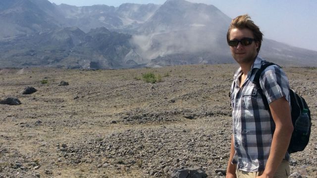 Dr Simon Barker stands in front of a volcanic plateau.