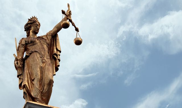 Scales of justice – A blind folded female statue holding scales and a sword.