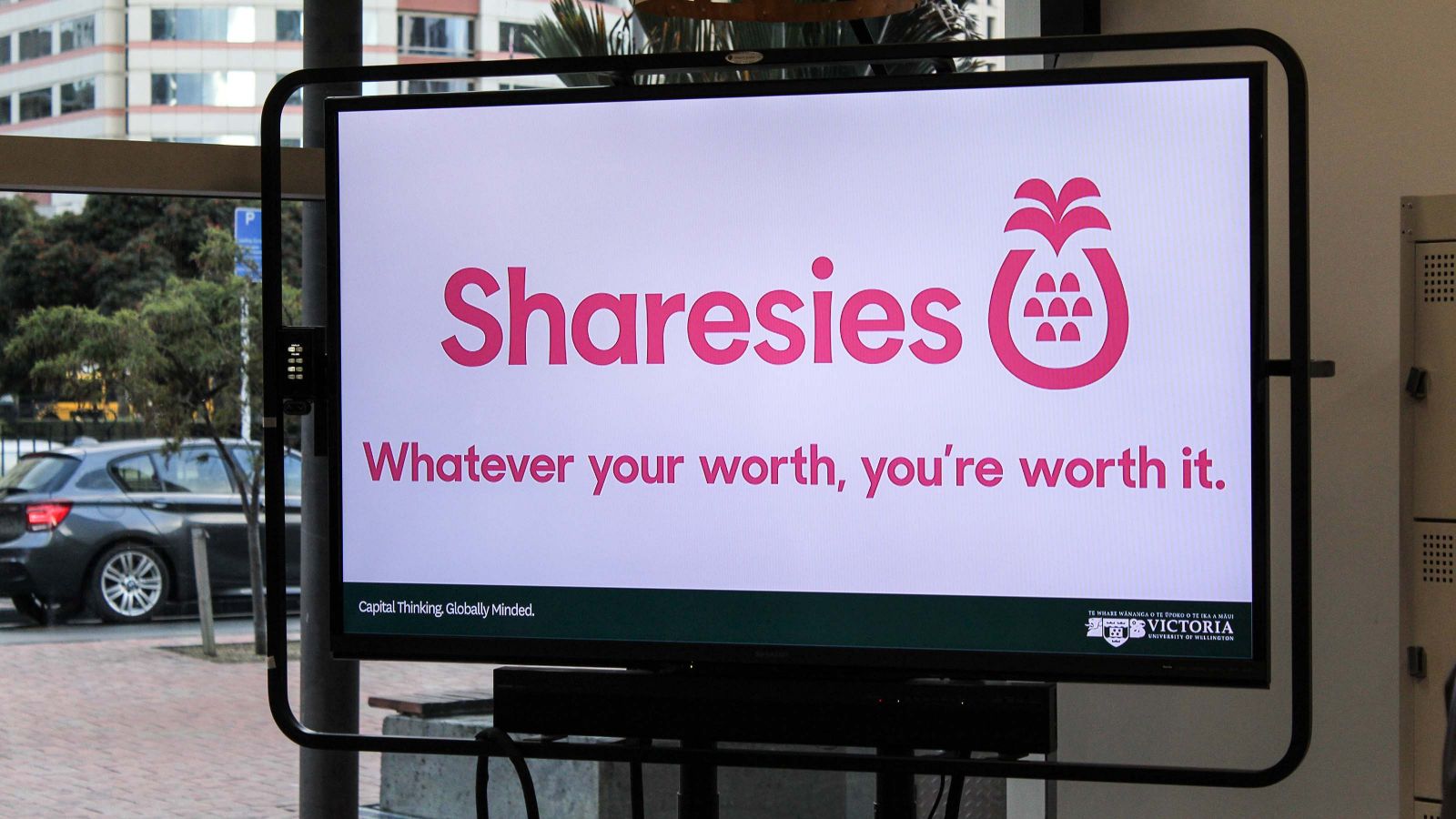 Television screen displaying the Sharesies logo in The Atom Innovation Space.