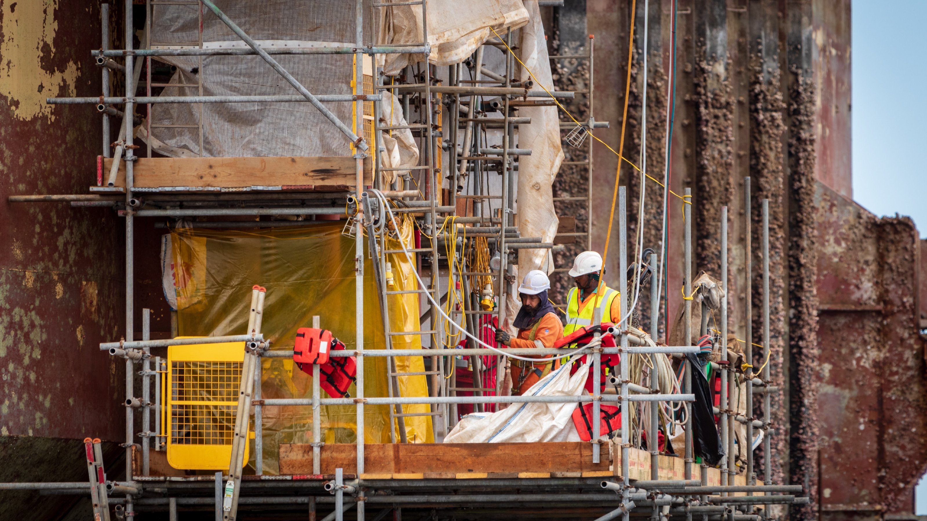 People on scaffolding work on a building