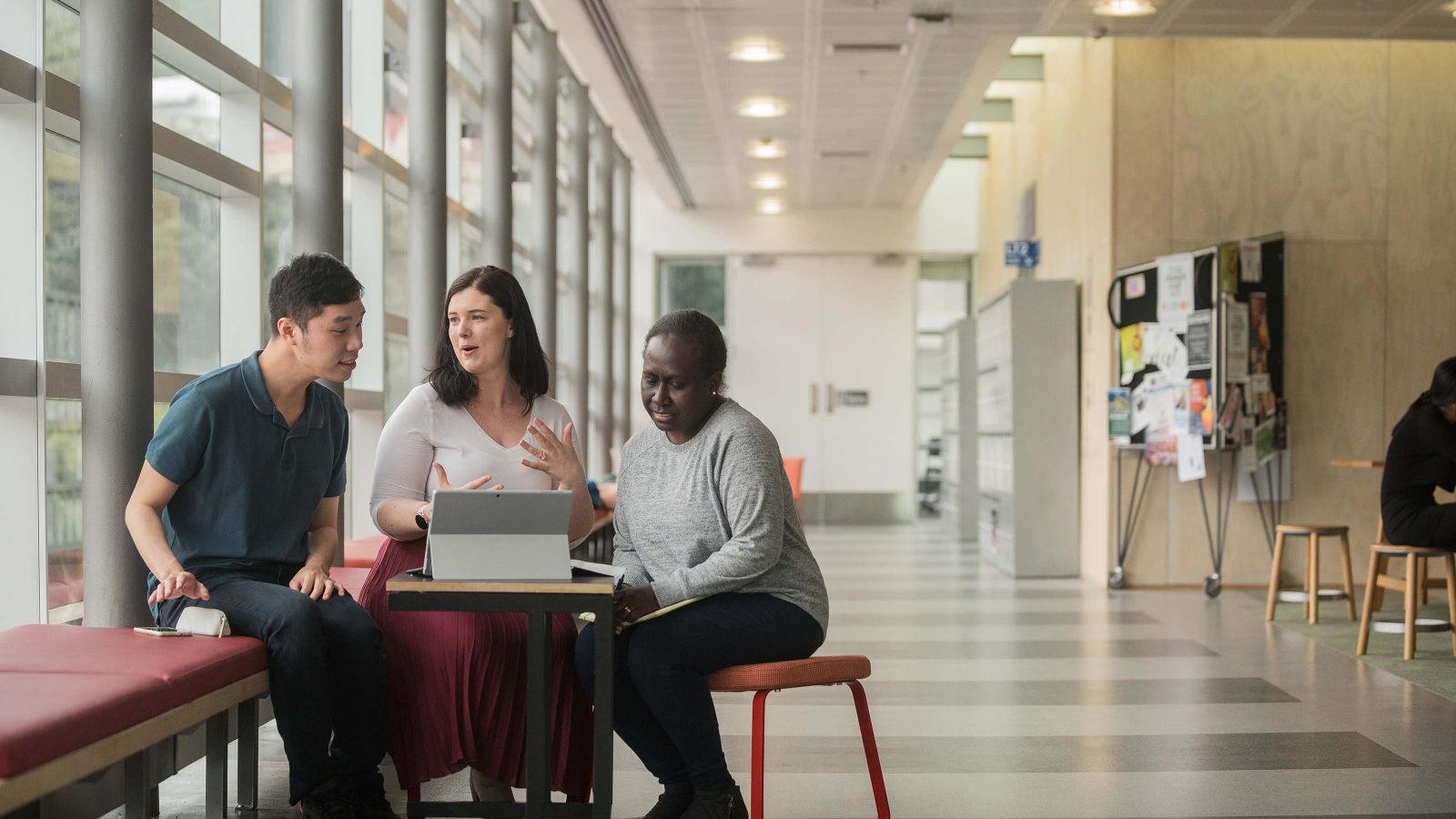Two students meet with a professional programmes adviser to discuss their studies.