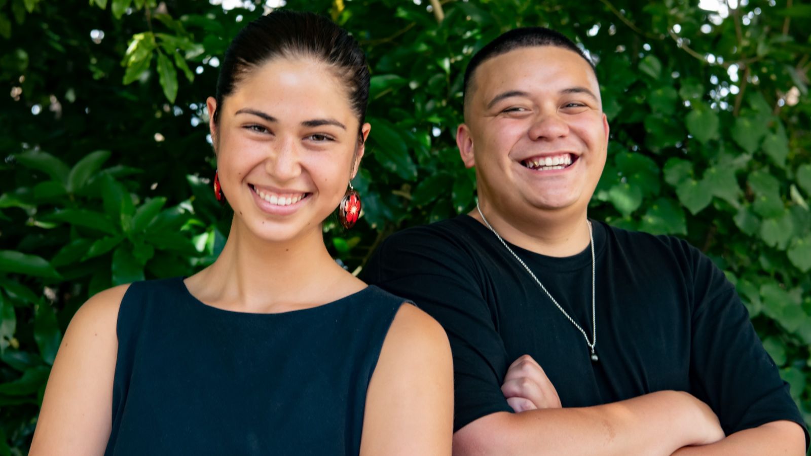 Litara and Dom smiling under a tree.