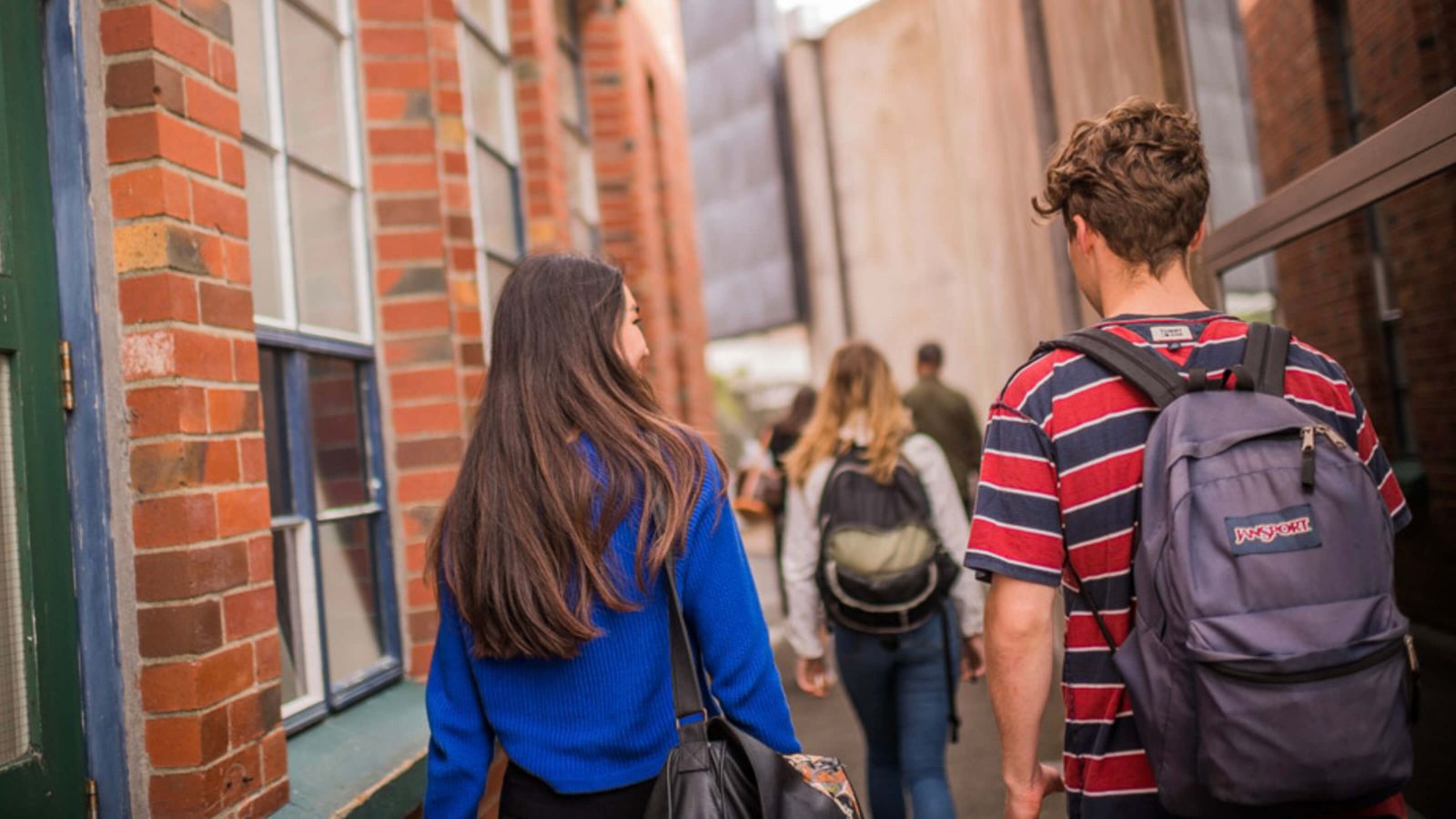 A group of students walking along the pavement between the Kirk building and Adam Art Gallery, towards the Hunter courtyard.