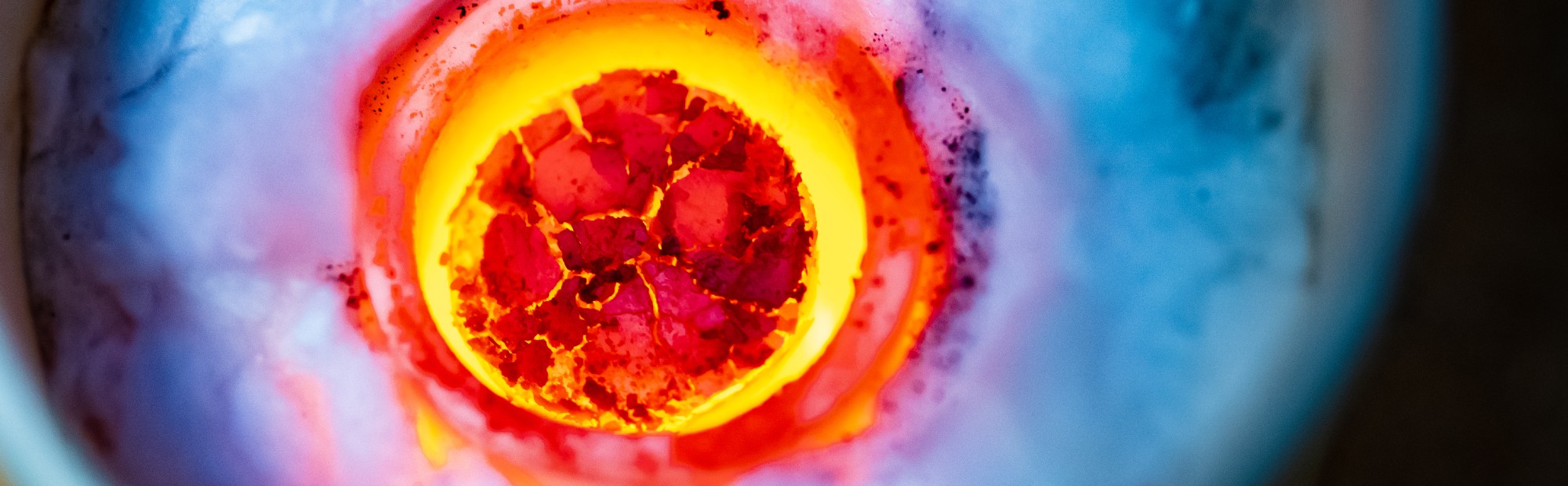 Vibrant red and yellow molten steel in a crucible.