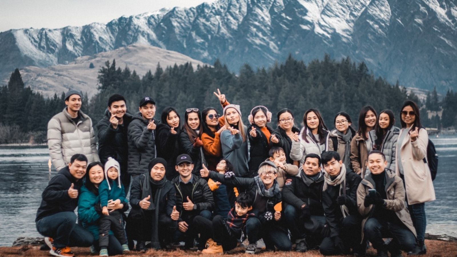 Formal group picture of members with lake and mountains in background.