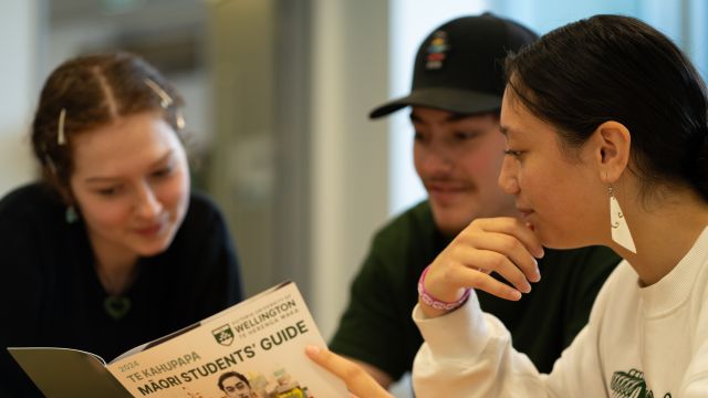 Three prospective Māori students look at the Māori Students' Guide together.