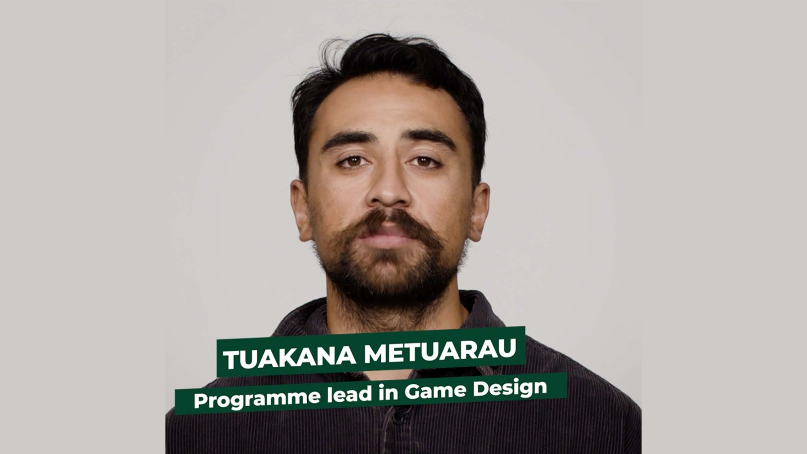 Tuakana Metuarau stands facing the camera against a grey background.