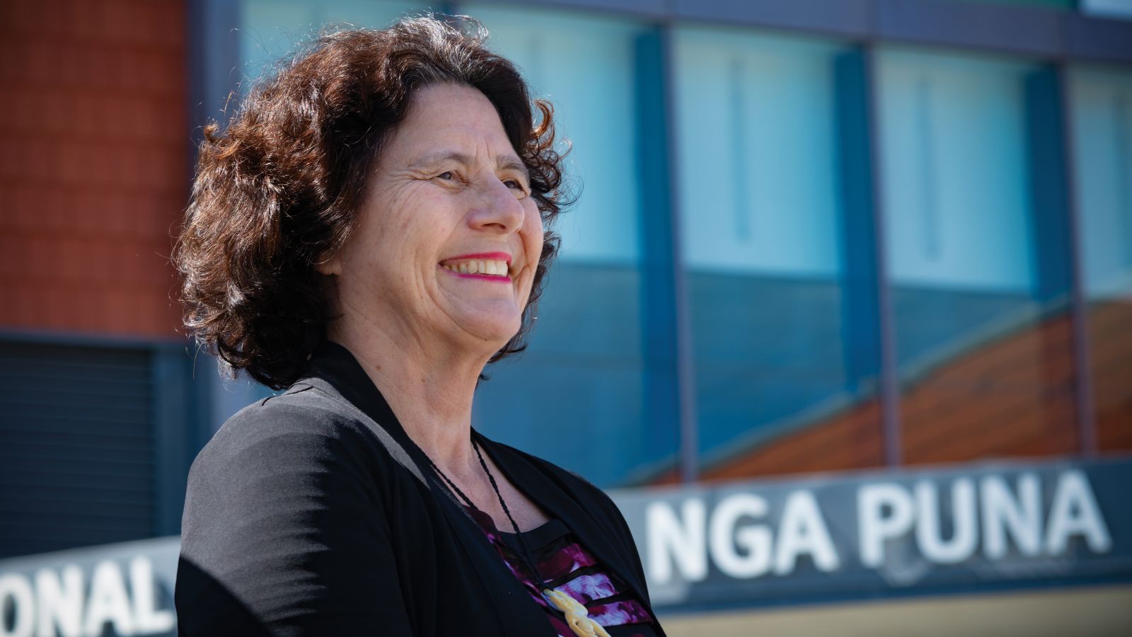 Professor Bev Lawton stands in front of Wellington Regional Hospital