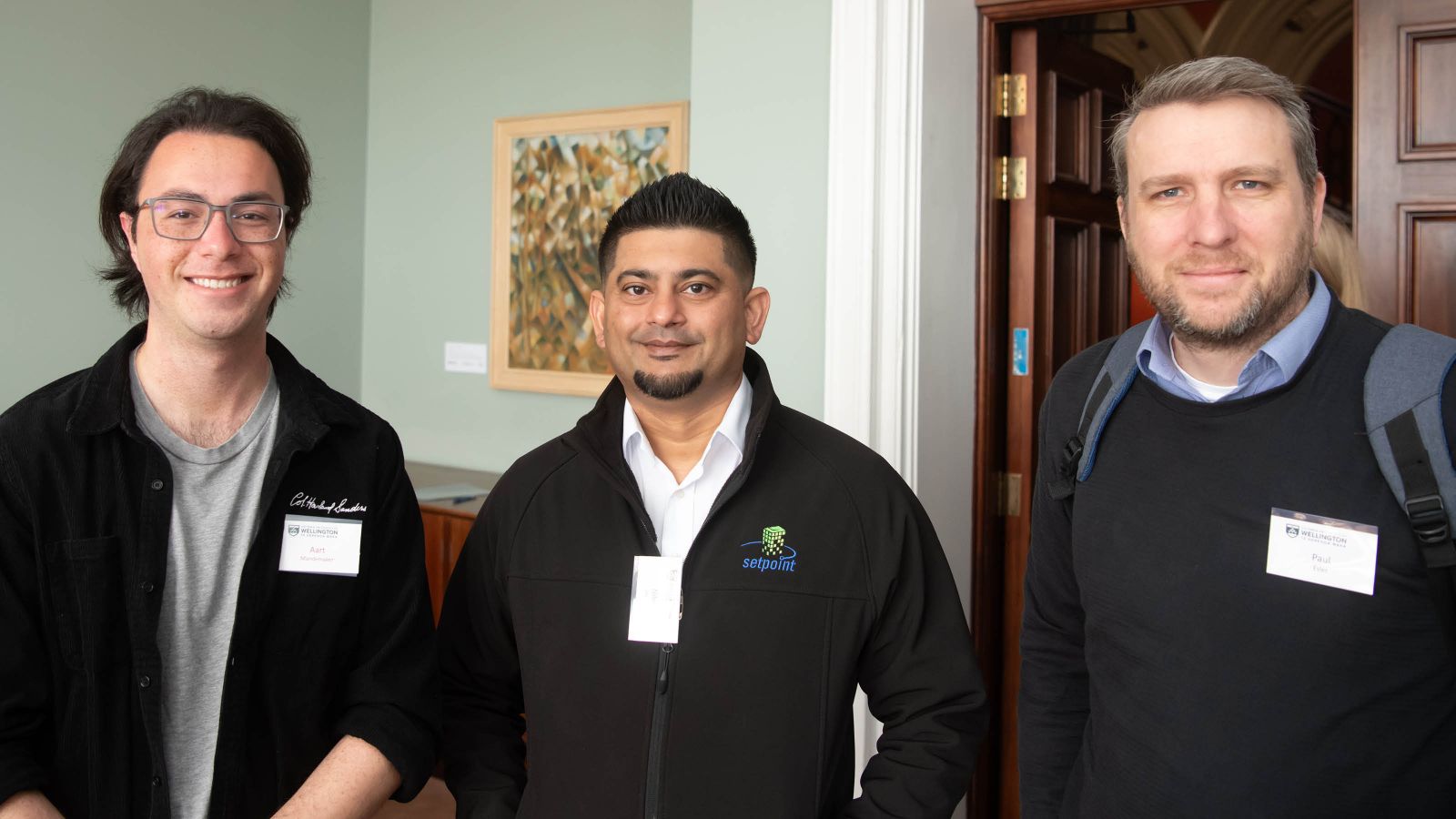 A student and two corporate sponsors smile at the camera