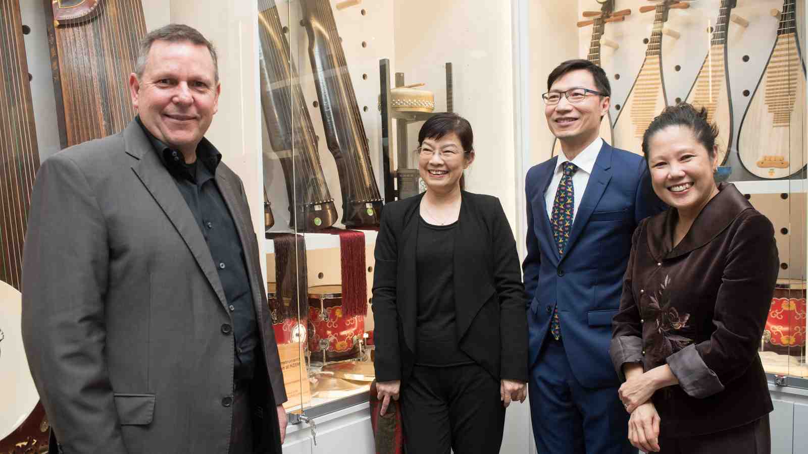 Director of NZSM Euan stands in front of the new instruments with members of the Confucius Institute