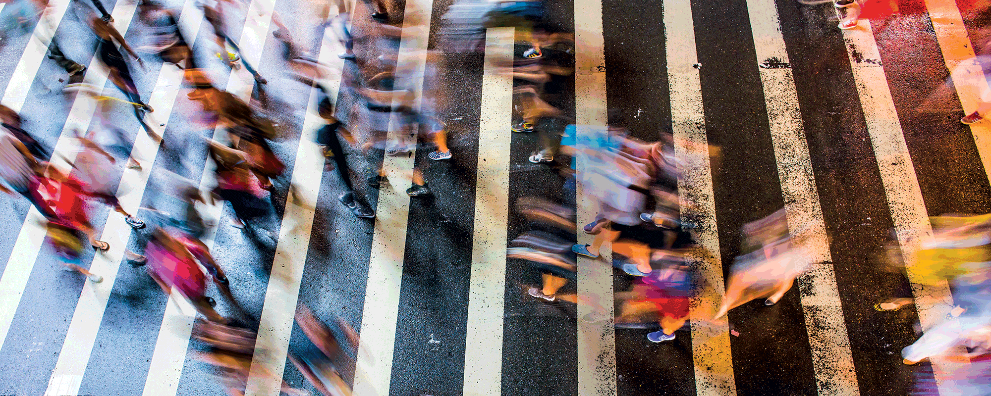 A timelapsed iamge of people using a crosswalk.