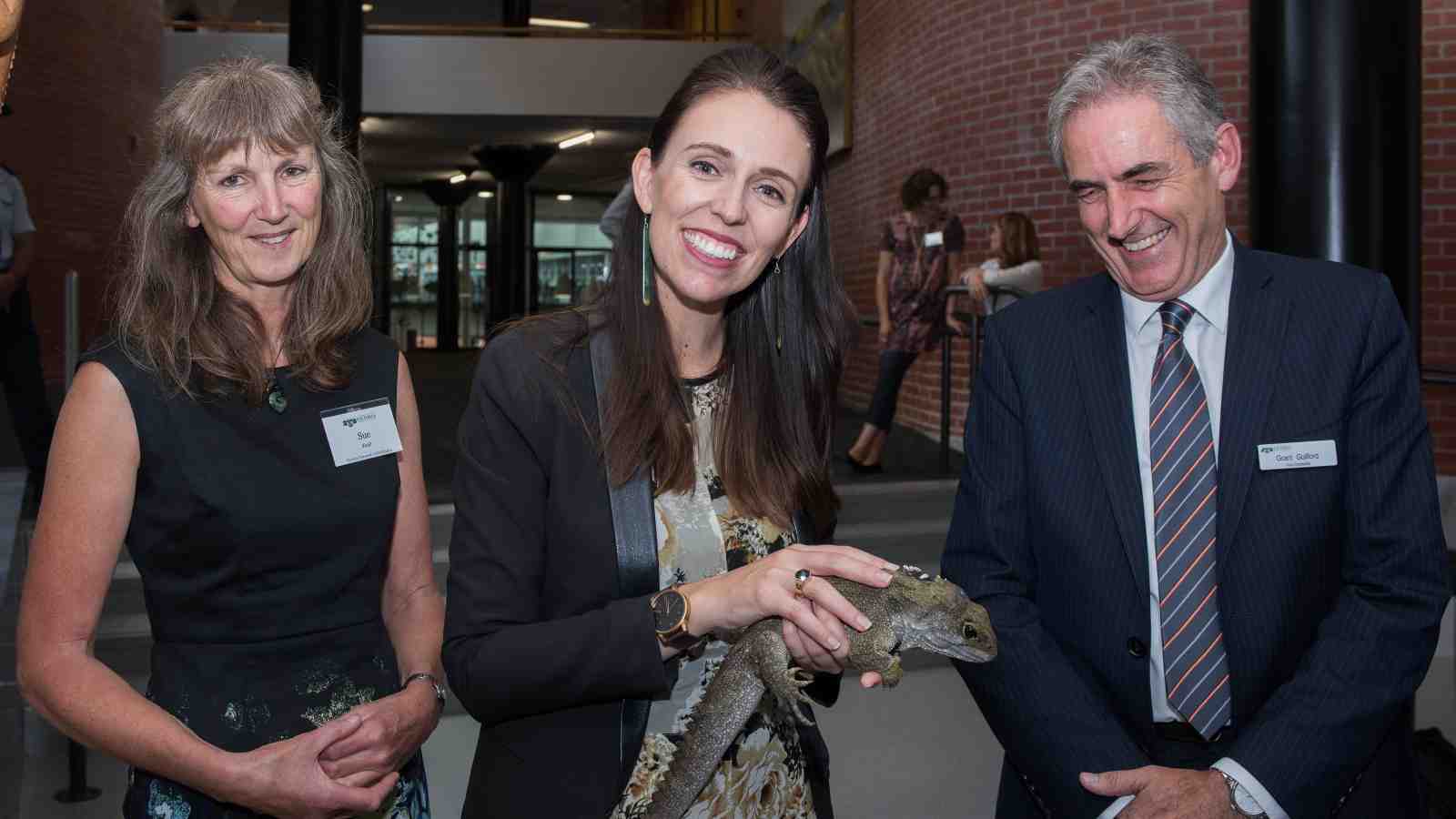 Prime Minister Jacinda Adern holds a tuatara as part of new science building opening ceremony.