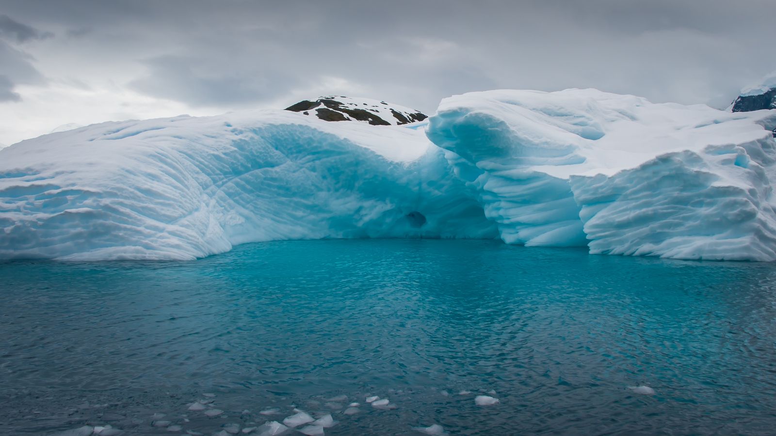 Landscape of an iceberg in a deep blue antarctic sea.