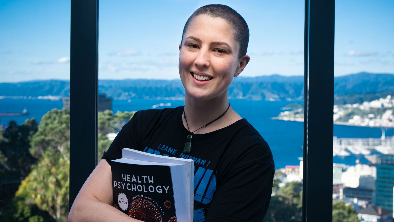 A portrait of Carly with the Wellington harbour in the background.