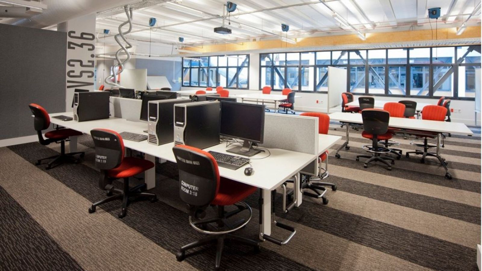 Unoccupied modern room with computer workstations and workdesks