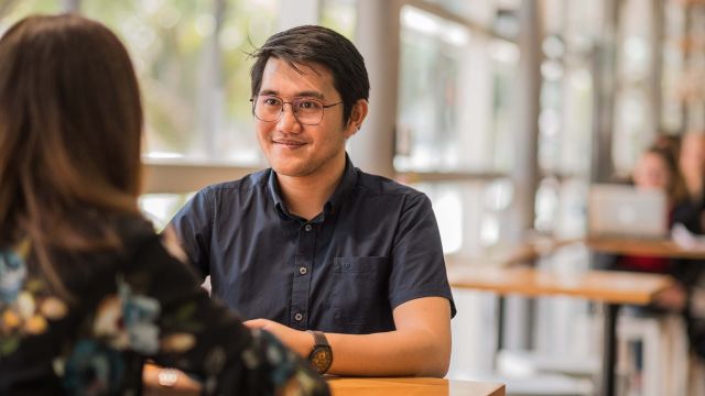 A student speaks to an academic at a cafe on the Wellington School of Business and Government campus