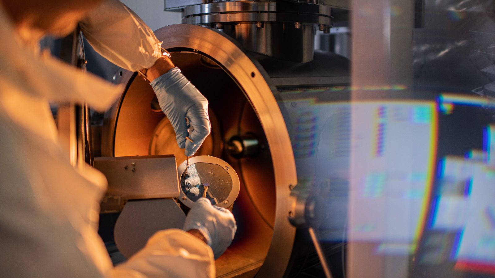 A scientist manipulating a sample in front of a furnace.