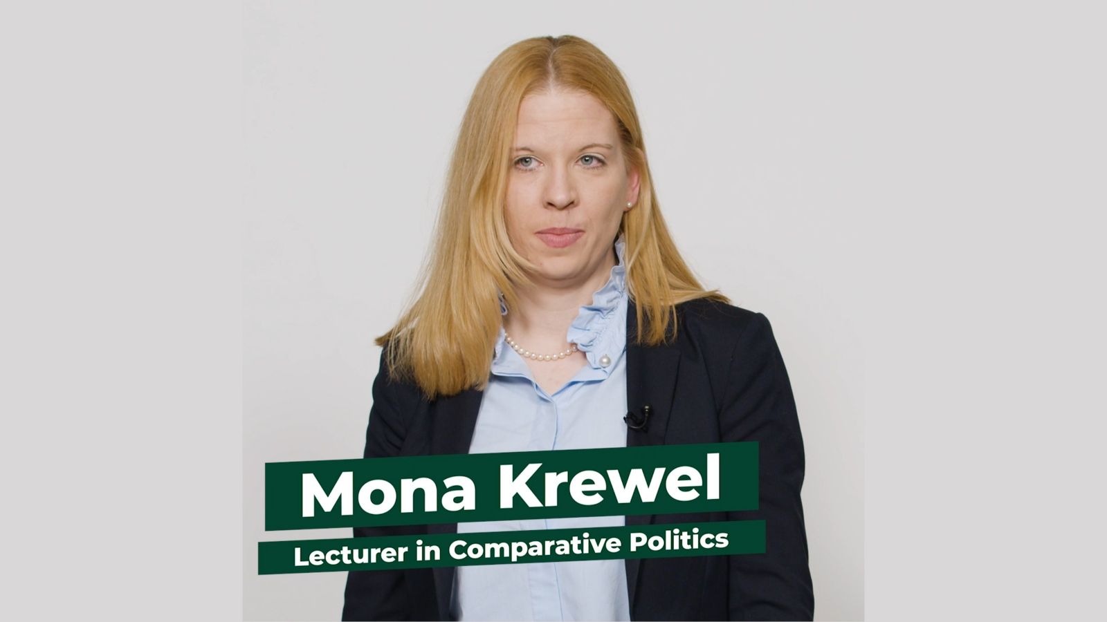Lecturer in Comparative Politics Mona Krewel stands facing the camera against a white backdrop