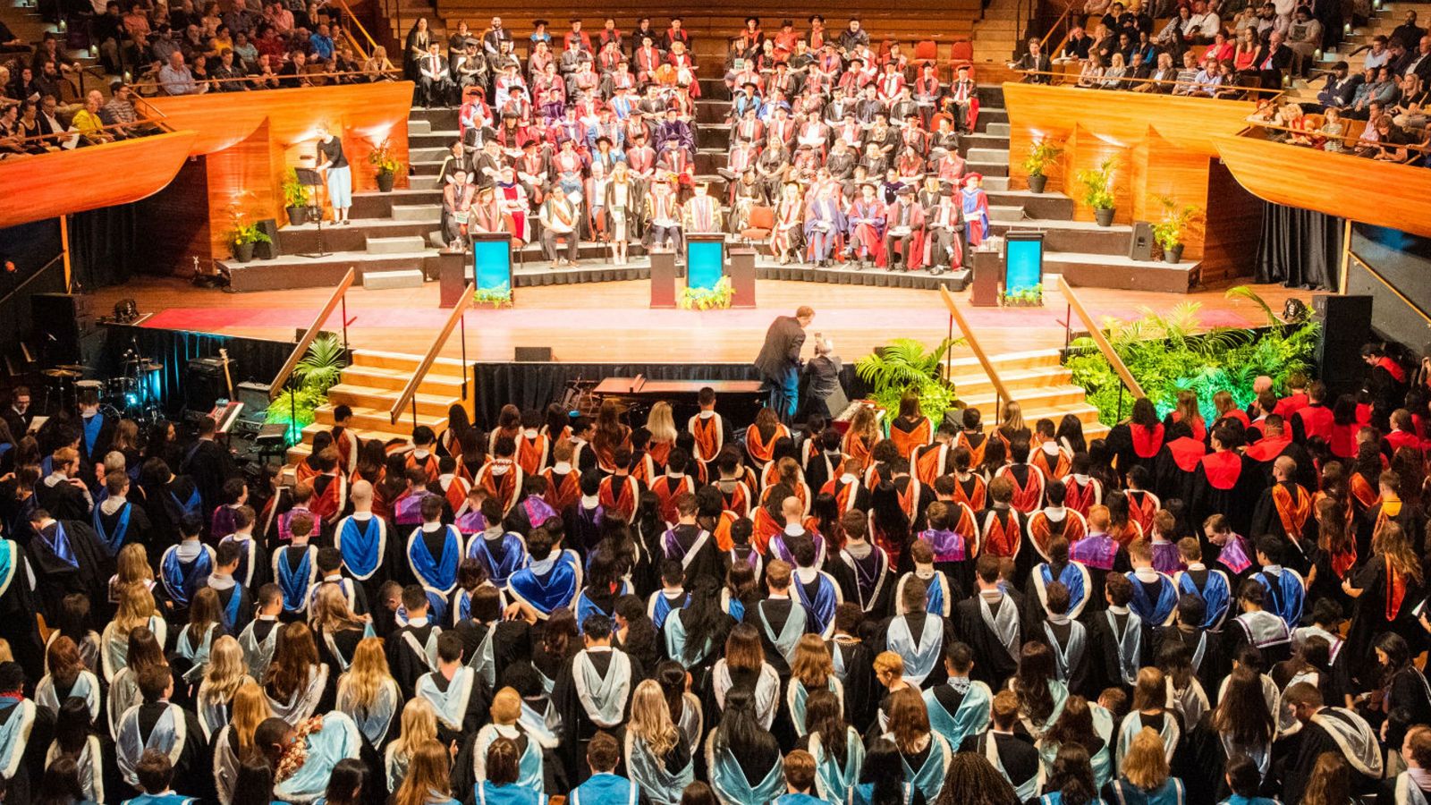 Aerial photograph of a large indoor graduation ceremony.
