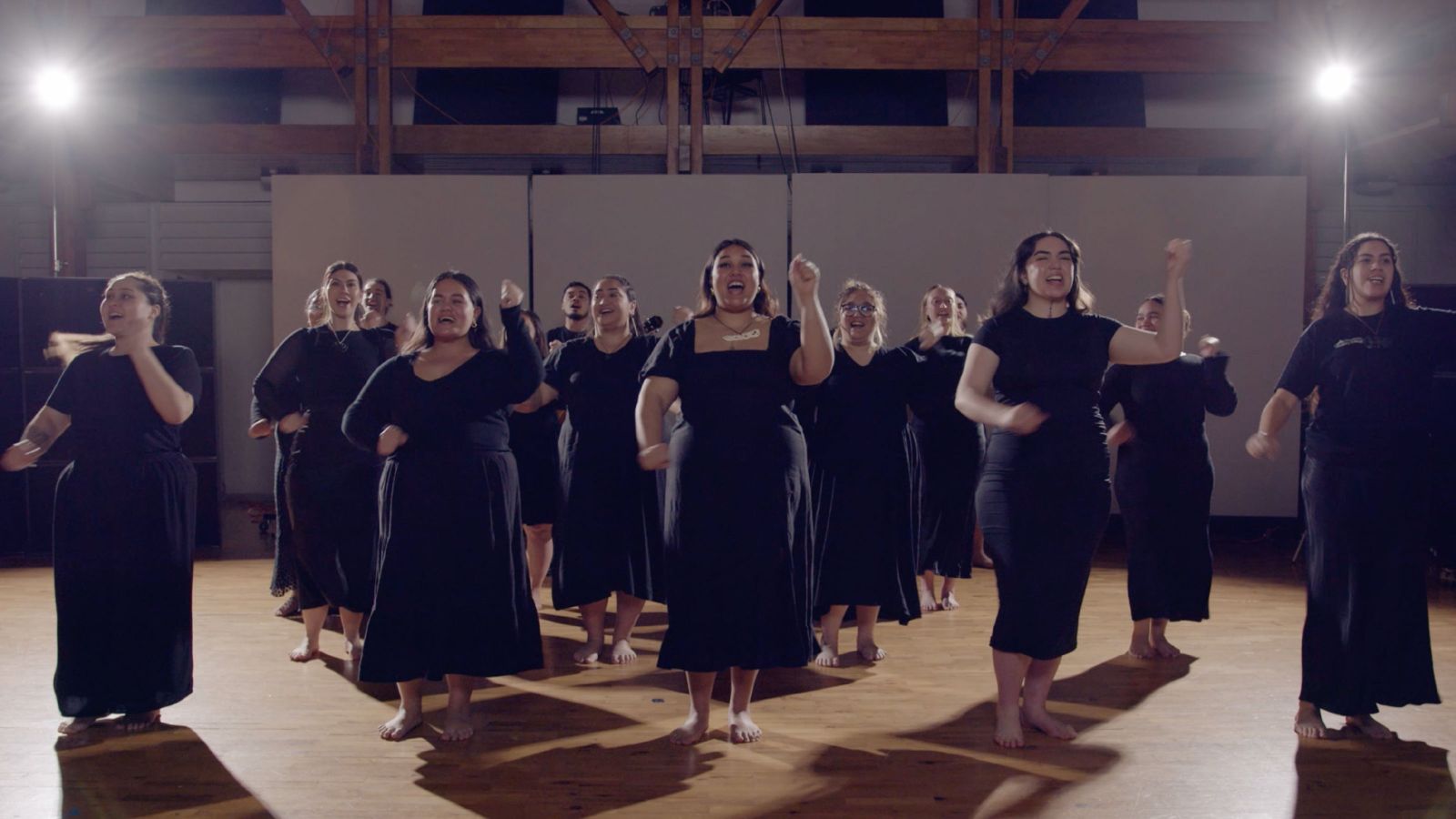 A group of women dancing and singing a song.
