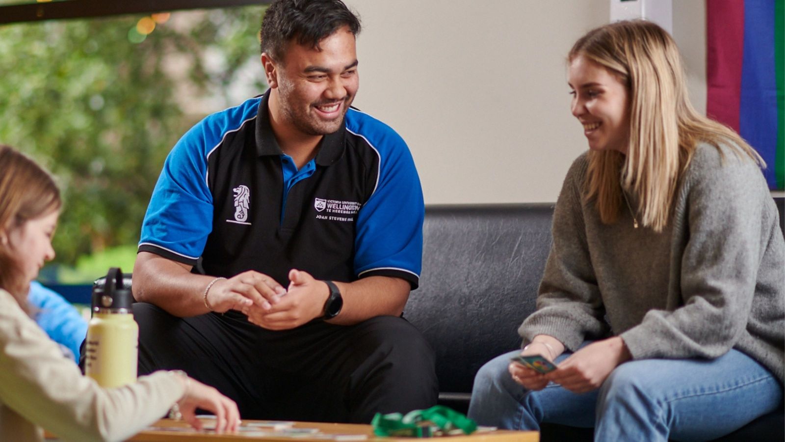 Staff and student playing cards at a university hall