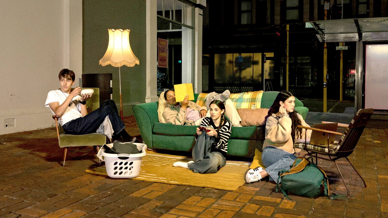 four students sitting on seats on Cuba Street