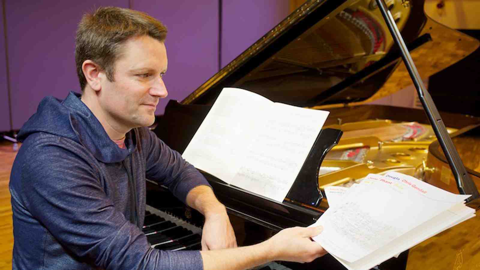 Michael Norris sitting at a grand piano.