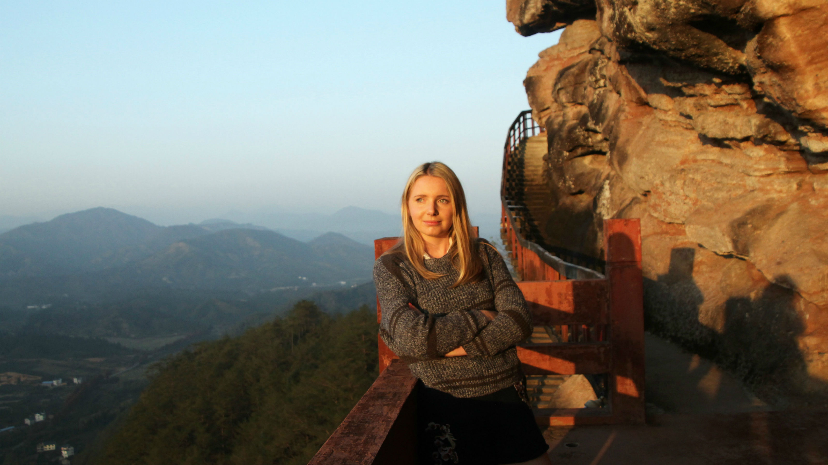 Kate, a Victoria student, standing on a rocky mountainside in China.
