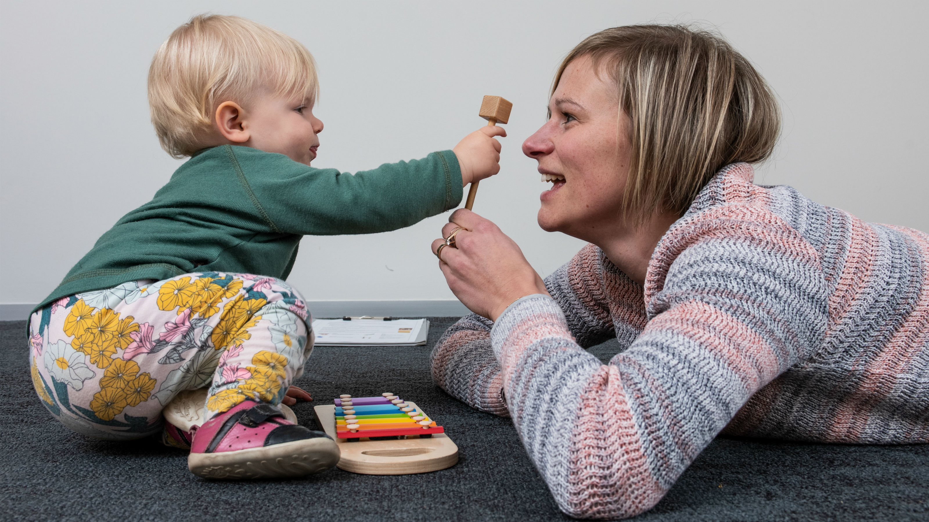 A small child and an instructor play with a xylophone