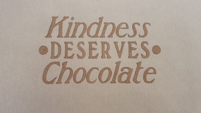 Writting on a box that says, kindness deserves chocolate.