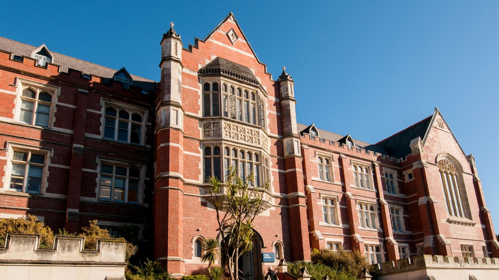 old building within university with label hunter building with blue sky