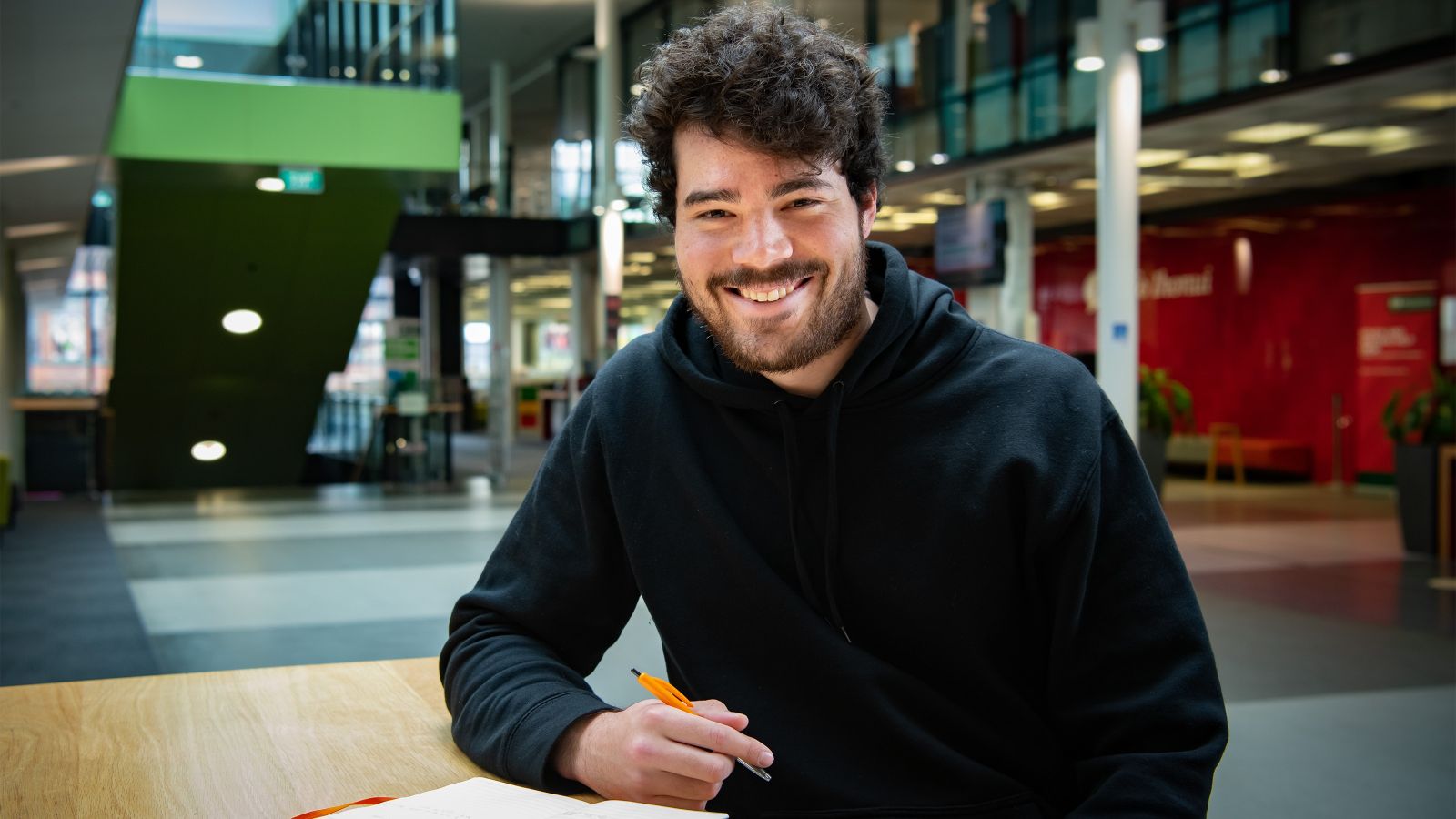 Anthony Charsley smiling while taking some notes