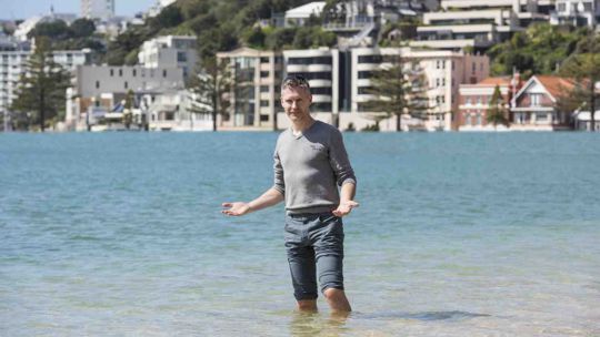 Nick Golledge standing quizzically knee-deep in Oriental Bay water