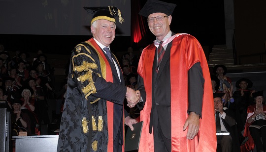 Jock Phillips shaking hands with Chancellor of Victoria University of Wellington in graduation robes