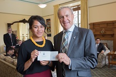 Salote wearing a black top and yellow necklace standing with Rt Hon David Carter who is presenting her with her prize 
